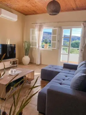 a living room with a blue couch and a table at Olives Villa in Anopoli Sfakion