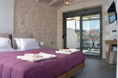 a bedroom with a purple bed with towels on it at Sun Flower Villas in Agia Marina Nea Kydonias