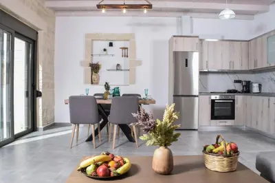 a kitchen and dining room with a table with fruit on it at Sun Flower Villas in Agia Marina Nea Kydonias