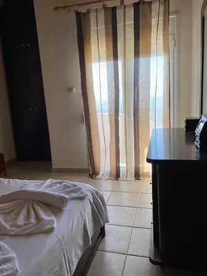 a bedroom with a bed and a table and a window at Evgoro in Chania Town