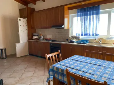 a kitchen with a table and a refrigerator and a sink at Evgoro in Chania Town