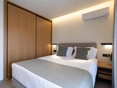 a bedroom with a large bed with a wooden headboard at Mossa Concept Villas - heated pool- 200 m from the beach in Daratso