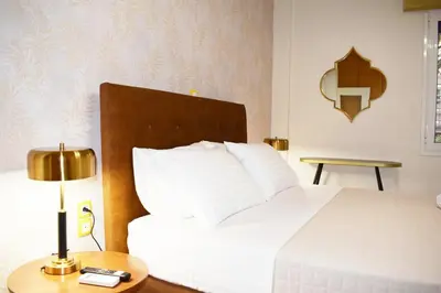a bedroom with a white bed and a table with a lamp at NAMA -Central vacation rental with free parking only 900m far from Venetian Port and beach! in Chania Town