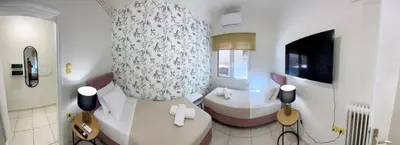 a room with a bedroom with a bed and a tv at NAMA -Central vacation rental with free parking only 900m far from Venetian Port and beach! in Chania Town