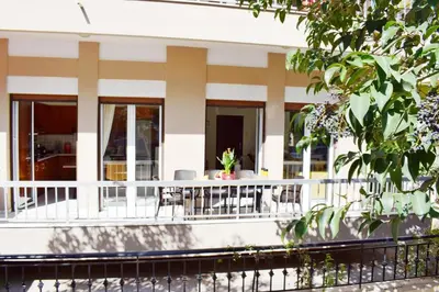a white building with tables and chairs on the balcony at NAMA -Central vacation rental with free parking only 900m far from Venetian Port and beach! in Chania Town