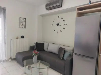 a living room with a couch and a clock on the wall at Eva's Suite in Chania Town