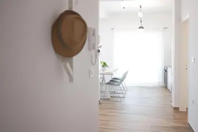a room with white walls and a table with chairs at Delvia Luxury Residence in Agios Onoufrios