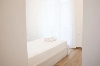 a white room with white curtains and a white mattress at Delvia Luxury Residence in Agios Onoufrios