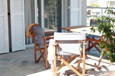 a patio with a table and chairs on a porch at Delvia Luxury Residence in Agios Onoufrios