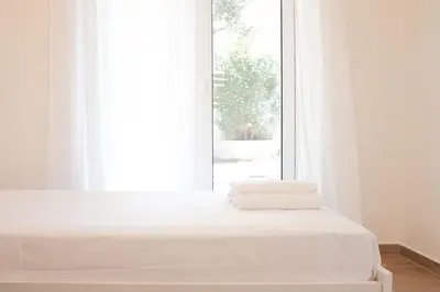 a white bed with towels on it in front of a window at Delvia Luxury Residence in Agios Onoufrios