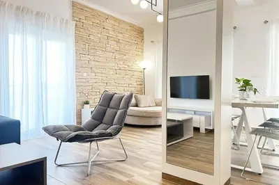 a living room with a couch and a chair and a television at Delvia Luxury Residence in Agios Onoufrios