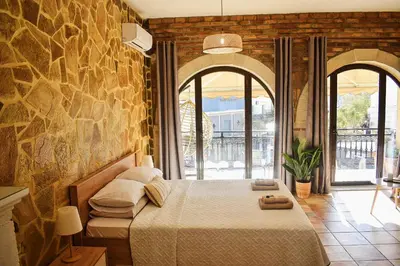a bedroom with a bed and a stone wall at Κρητικό παραδοσιακό διαμέρισμα! in Chania Town