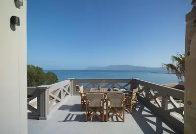 a table and chairs on a balcony overlooking the ocean at Zoe's Place - 1 BD Loft Beachfront Apartment in Kissamos