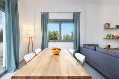 a dining room with a wooden table with a bowl of fruit at Sea Apt - Akrotiri in Kounoupidhianá