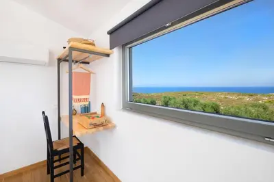 a room with a window with a desk and a chair at Sea Apt - Akrotiri in Kounoupidhianá