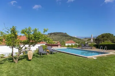 a swimming pool in a yard with chairs and a tree at VILLA APELLA - PRIVATE HEATED POOL in Nohia