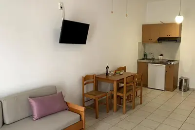 a living room with a couch and a table and a kitchen at Michael Apartments 2 in Agia Marina Nea Kydonias