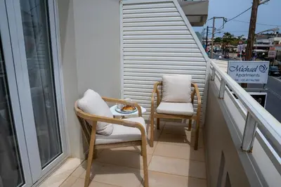 two chairs sitting on a balcony with a window at Michael Apartments 2 in Agia Marina Nea Kydonias