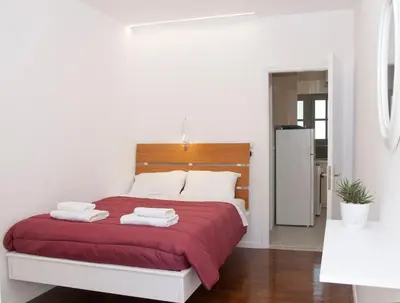 a bedroom with a red bed with towels on it at Vabis Koum - Kapi in Chania Town