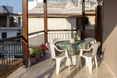 a balcony with a table and chairs on a balcony at Big spacious apartment in the heart of the city! in Chania Town