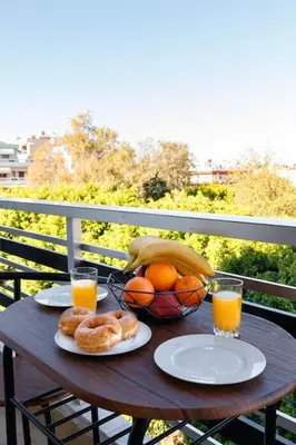 a wooden table with a basket of fruit and orange juice at TziApartment in downtown Chania in Chania Town