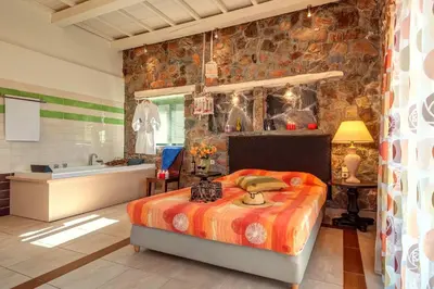 a bedroom with a bed and a stone wall at Seaview villa Amphitriti with Private Pool, 20 min from Elafonissi beach in Chania Town