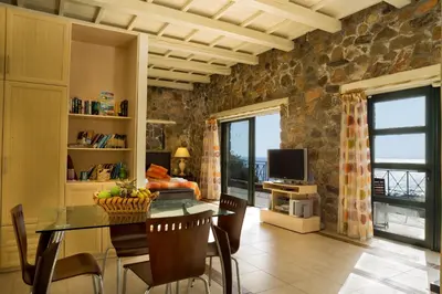 a dining room with a table and a television at Seaview villa Amphitriti with Private Pool, 20 min from Elafonissi beach in Chania Town