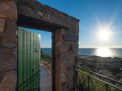 a door to a stone building with the ocean behind it at Seaview villa Amphitriti with Private Pool, 20 min from Elafonissi beach in Chania Town