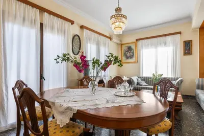 a dining room with a wooden table with flowers on it at Sunset Apartment in Platanias in Plataniás