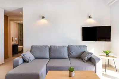 a living room with a couch and a tv at Dreta Suites in Chania Town