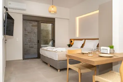 a bedroom with a bed and a table and a dining room at Dreta Suites in Chania Town