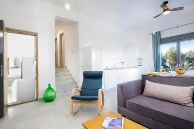 a living room with a couch and a chair at Olisea Villa, olive grove seaview villa in Kounoupidhianá