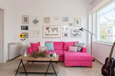a pink couch in a living room with a table at House of joy close to Chania center in Chania Town