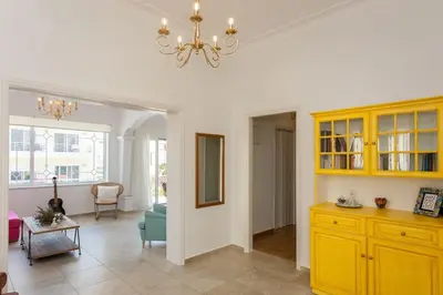 a living room with yellow cabinets and a table at House of joy close to Chania center in Chania Town
