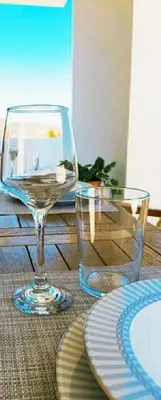 a wine glass and a plate on a table at White Dome Apartment I in Souda