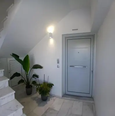 a hallway with a white door and a potted plant at White Dome Apartment I in Souda