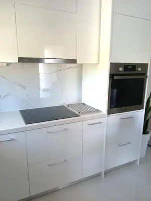 a white kitchen with a stove and a microwave at White Dome Apartment I in Souda