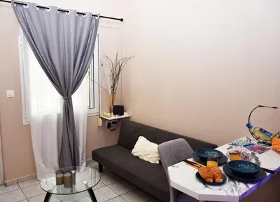 a living room with a couch and a table at Relaxed Dream home in Chania Town