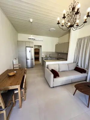 a living room with a couch and a table and a kitchen at The Gem Of Talos Apartment in Stalos
