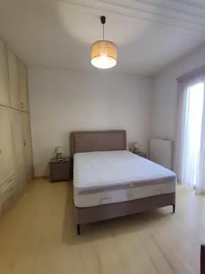 a bedroom with a bed and a light fixture at The Gem Of Talos Apartment in Stalos