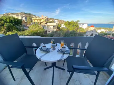 a table and chairs on a balcony with a view at Rouan Studios in Souda