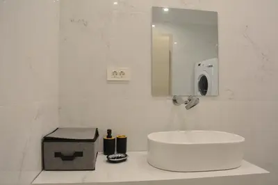 a white bathroom with a sink and a mirror at Para thin alós House in Chania Town