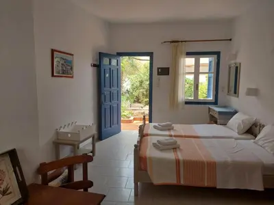 a bedroom with a bed and a blue door at Lissos Studios - Rooms in Palaiochóra