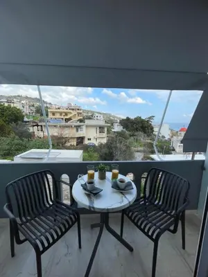 a table and chairs on a balcony with a view at Rouan studios 1 in Souda