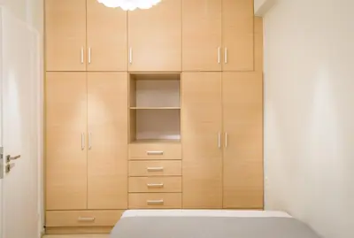 a closet with wooden cabinets and a bed in a room at ELflat - chania city living in Chania Town