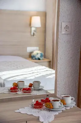 a room with a bed and a table with cups and plates of food at Studios George in Palaiochóra