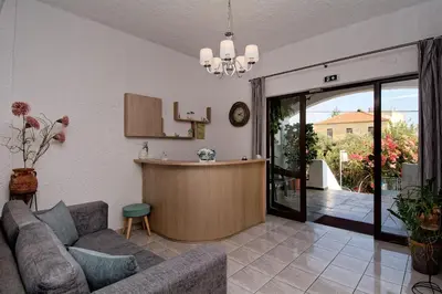 a living room with a couch and a kitchen at Studios George in Palaiochóra