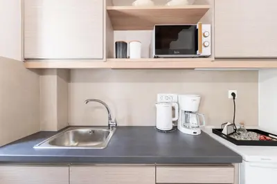 a small kitchen with a sink and a microwave at Casa Di Sabbia in Chania Town