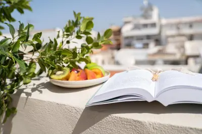 an open book on a table with a bowl of fruit at Casa Di Sabbia in Chania Town