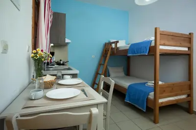 a room with a table and a bunk bed at Kalami Apartments in Falasarna